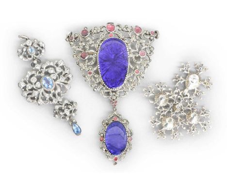 An Enamel, Garnet and Marcasite Brooch/Pendant, the oval blue enamel plaque within a scroll and foliate border set throughout