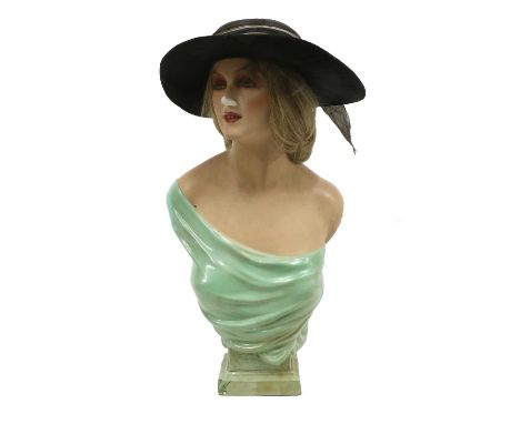 A Circa 1930s Mannequin Head and Torso with glass eyes, open mouth showing teeth, with a green drape covering the torso on a 