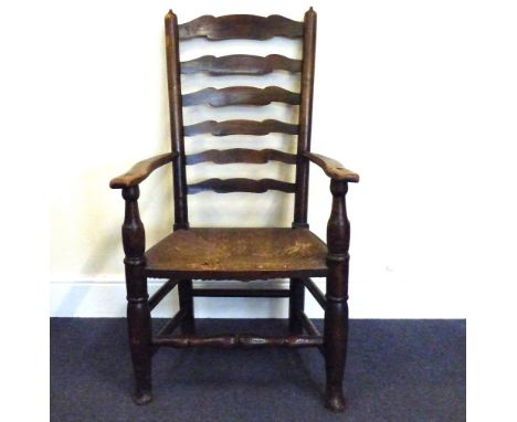A 19th century Lancashire ladder back open armchair with rush seat and bobbin turned stretcher.