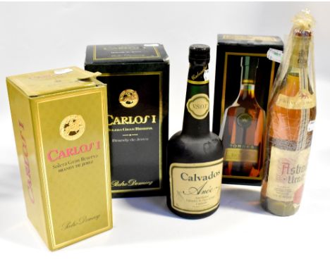 Five boxed and unboxed bottles of brandy comprising a boxed Carlosi Grand Reserve, a boxed Miguel Torres, a boxed Carlosi Gra