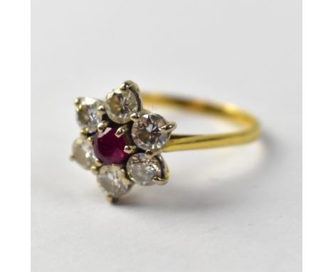An 18ct gold ring with central claw set ruby within a flower setting of six small claw set diamonds, each approx 0.25ct, tota