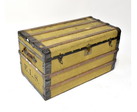 A metal bound canvas covered travelling trunk with leather carrying handles, initialled 'E.L.S.', with remnants of luggage la