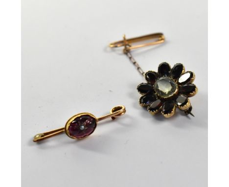 Two early 19th century brooches comprising a rose gold bar brooch with bezel set half garnet cabochon, set with seed pearl in