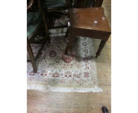 A WOOL RUG the beige light brown and green ground with panels filled with palmets within a floral border 236cm x 153cm