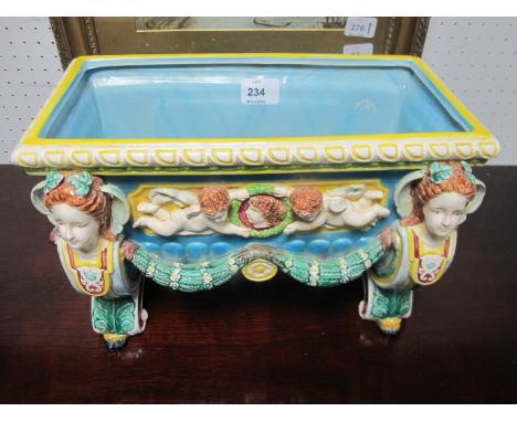 A MAJOLICA PLANTER of rectangular form the light blue, green and yellow ground with figural masks moulded in relief with wing