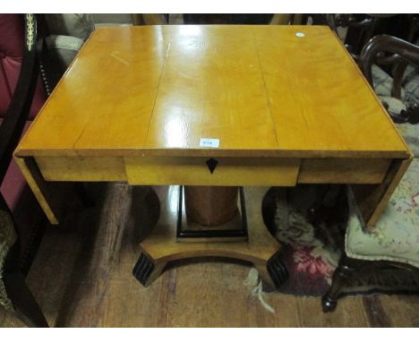 A BIEDERMEIER SATIN BIRCH AND EBONISED SOFA TABLE the rectangular hinged top above a frieze drawer raised on a cylindrical co