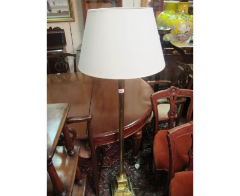 A BRASS FLOOR STANDARD LAMP the reeded column with Corinthian capital above a square stepped base with claw feet 155cm high