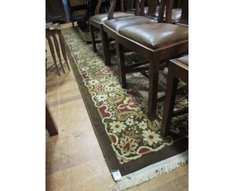 A WOOL RUG the light brown and beige ground with central floral panel within a conforming border 350cm x 250cm