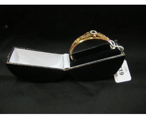 AN ANTIQUE 9CT YELLOW GOLD GARNET AND PEARL BANGLE