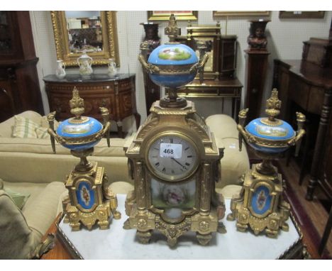 A FRENCH GILT BRASS AND PORCELAIN CLOCK GARNITURE 19th Century the rectangular arched case with enamel dial surmounted with a