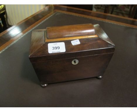A VICTORIAN MAHOGANY TEA CADDY of rectangular tapering form the hinged lid containing compartments raised on bun feet