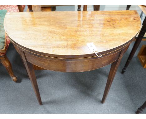 A George III mahogany and boxwood strung D shaped folding card table, width 91cm, depth 45cm, height 74cm