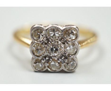 An 18ct and collet set nine stone diamond cluster table ring, size K/L, gross weight 2.6 grams.