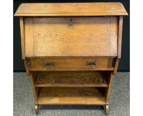 An Arts &amp; Crafts oak student's bureau, fall front enclosing pigeonholes, above a drawer and a bookcase shelf, 105cm high,