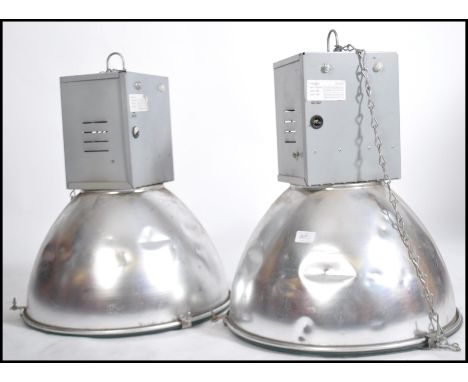 A pair of 20th century industrial pendant light having polished metal half moon spherical shades with bracket and box mounts 
