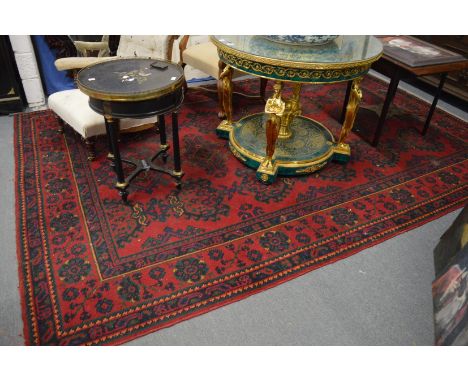 A large Turkish carpet, red ground with stylised decoration (cut and repaired), 380cm x 250cm.