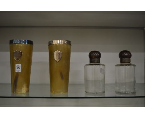 A pair of large silver mounted horn beakers together with a pair of glass scent bottles with horn tops.