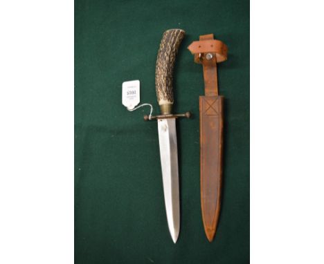 A hunting knife with horn handle and leather sheath.
