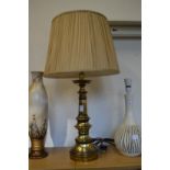 A large brass table lamp and shade.