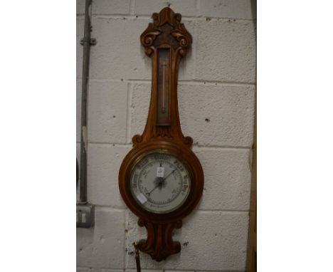 Carved oak cased barometer and thermometer.