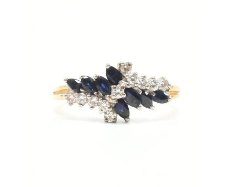 A gold sapphire and diamond crossover cluster ring. The ring set with marquise cut sapphire and round brilliant cut diamonds 