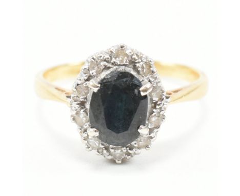 A vintage 18ct yellow gold, sapphire and diamond halo ring. The ring having an oval cut sapphire surrounded by a cluster of r