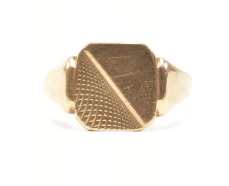 A hallmarked 9ct yellow gold signet ring. The ring having a rounded square head half etched with graduating cross hatch patte