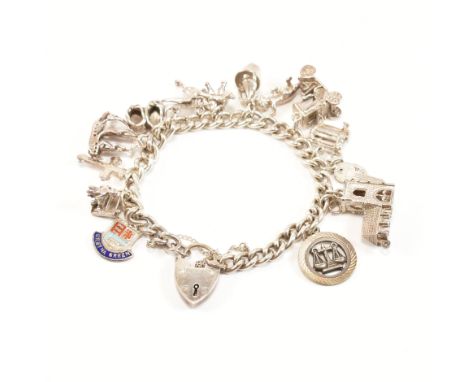 A vintage silver charm bracelet with charms. The chain comprised of curb links united by a heart padlock clasp and safety cha