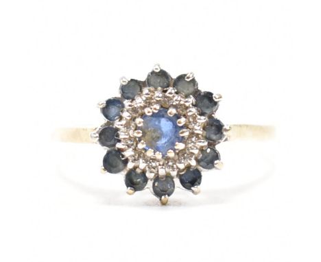 A hallmarked 9ct gold sapphire and diamond cluster ring. The ring set with a central round mixed cut sapphire framed by diamo