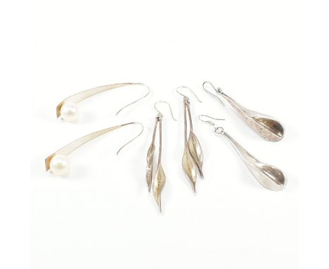 A group of three 925 silver earrings. The lot to include three pairs of hook drop statement silver earrings, one with simulat