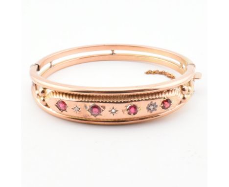 A garnet, paste and diamond bangle. The bangle set with garnets, paste and diamonds to the head having beaded decoration to b