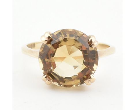 A hallmarked 9ct gold and citrine cocktail ring. The ring set with a round mixed cut citrine to plain shank. Weight 3.7g. Siz