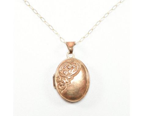 A vintage 9ct gold locket pendant on chain necklace. The pendant of oval form with scrolling repousse detailing and hinged op
