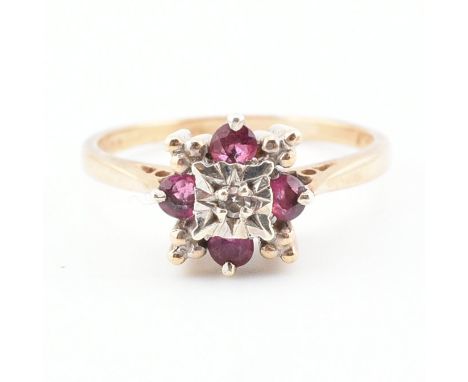 A hallmarked 9ct gold ruby and diamond cluster ring. The ring set with a central illusion cut diamond framed by round cut rub