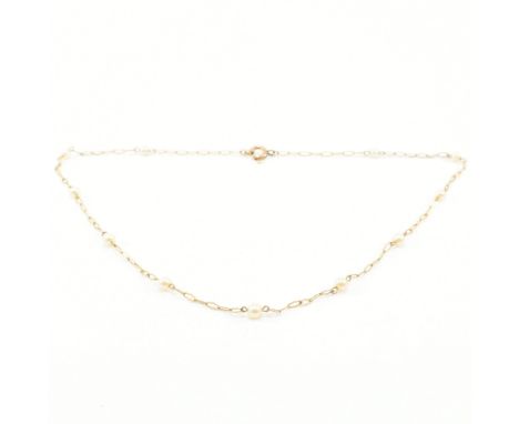 A 1920s pearl necklace. The necklace formed with serpentine fancy links having pearl spacers united by spring hoop clasp. Unm