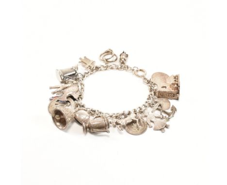 A vintage sterling silver charm bracelet with charms. The bracelet comprised of curb links united by a spring ring clasp, mar