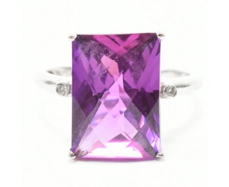 A vintage 9ct white gold, synthetic sapphire and diamond dress ring. The ring having a rectangular cut magenta pink sapphire 