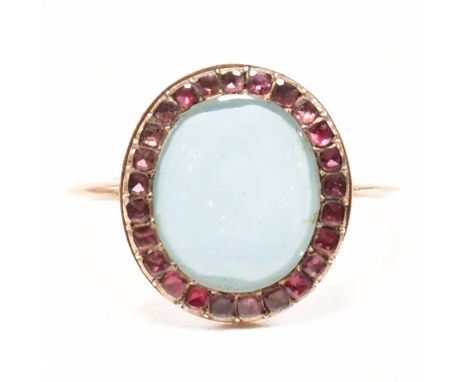 A Georgian gold and garnet locket ring. The ring having a central glazed panel framed by flat cut garnets to plain band ring.