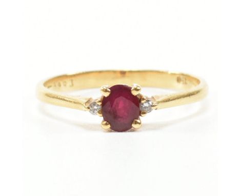 A vintage 18ct yellow gold, ruby and diamond ring. The ring having an oval cut prong basket set ruby flanked by an accent dia