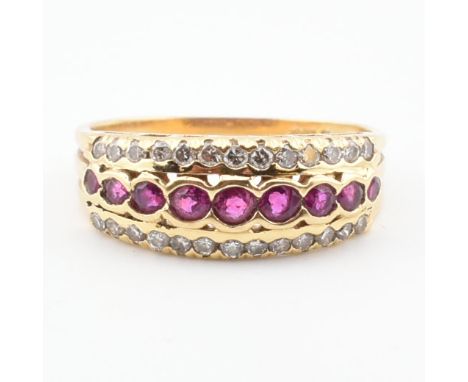 A hallmarked 18ct gold ruby and diamond band ring. The ring set with a central row of rubies flanked by two rows of round bri