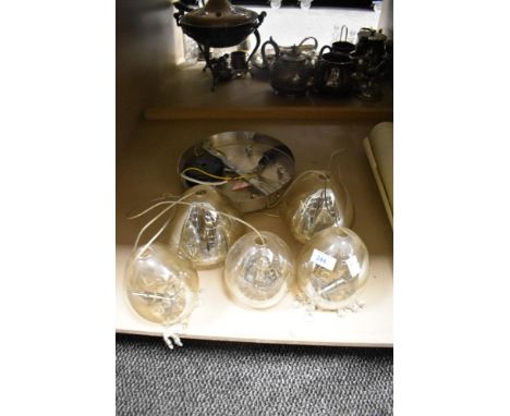 A vintage glass ceiling light fitting with five suspended glass shades