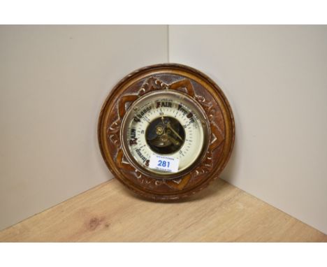 A late Victorian walnut cased aneroid barometer, with skeleton movement surrounded by enamelled dial and bevelled glass front
