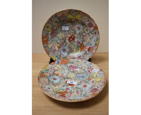 A pair of Chinese Millefiori Famille Rose plates, both painted with colourful flower heads, and bearing a red Qianlong six ch