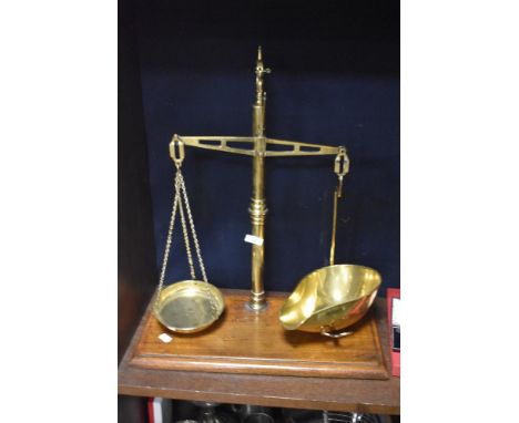 A set of late 19th/early 20th century brass scale with mahogany base.
