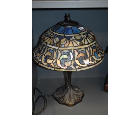 An attractive 20th Century Tiffany style stained glass lamp, of Art Nouveau style, the shade comprising tones of blue, all ra