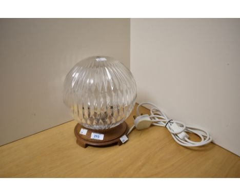 An Art Deco style table lamp, having spherical cut glass shade and raised on a footed oak base, measuring 24cm high