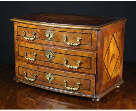 A Miniature 18th Century Walnut Veneered Bowfront Commode inlaid with decorative bands and stringing and having cast brass sw