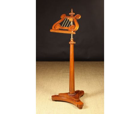 A 20th Century Mahogany Music Stand in the William IV Style.  The lyre shaped manuscript rest on ratchet support above a tape