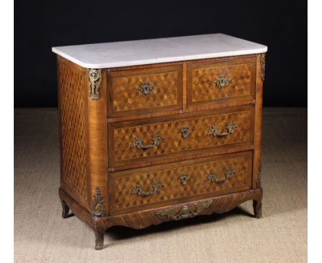 A 19th Century Parquetry Commode with white marble top.  The chest housing two short over two long drawers with gilt metal mo