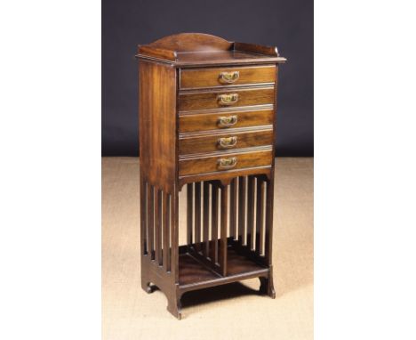 An Edwardian Music Cabinet. The top with rails to the back and sides above five drop-front music drawers with manuscript rack